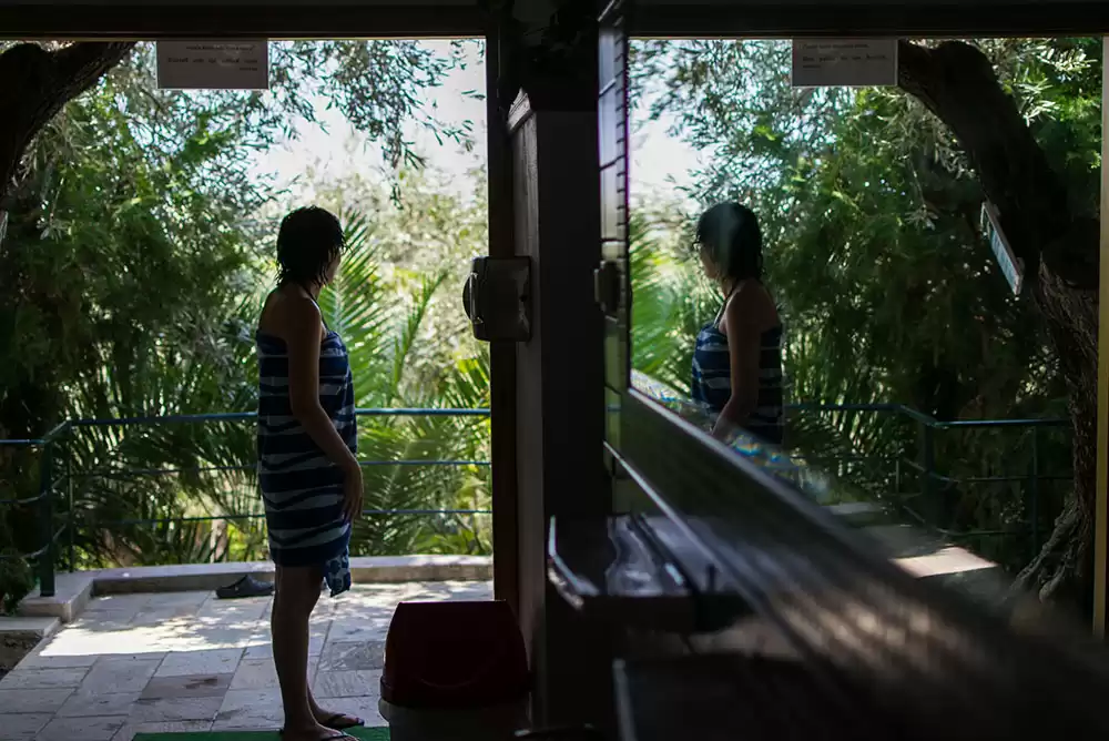 Woman stands in front of a glass shower