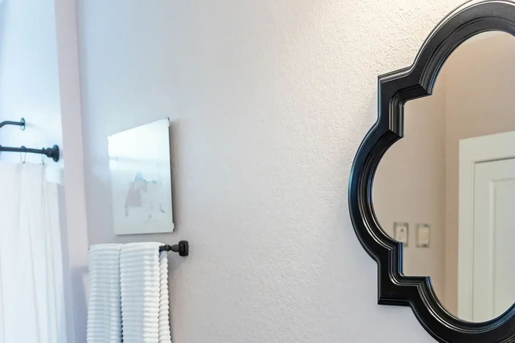 bathroom with a custom shaped mirror hanging on wall