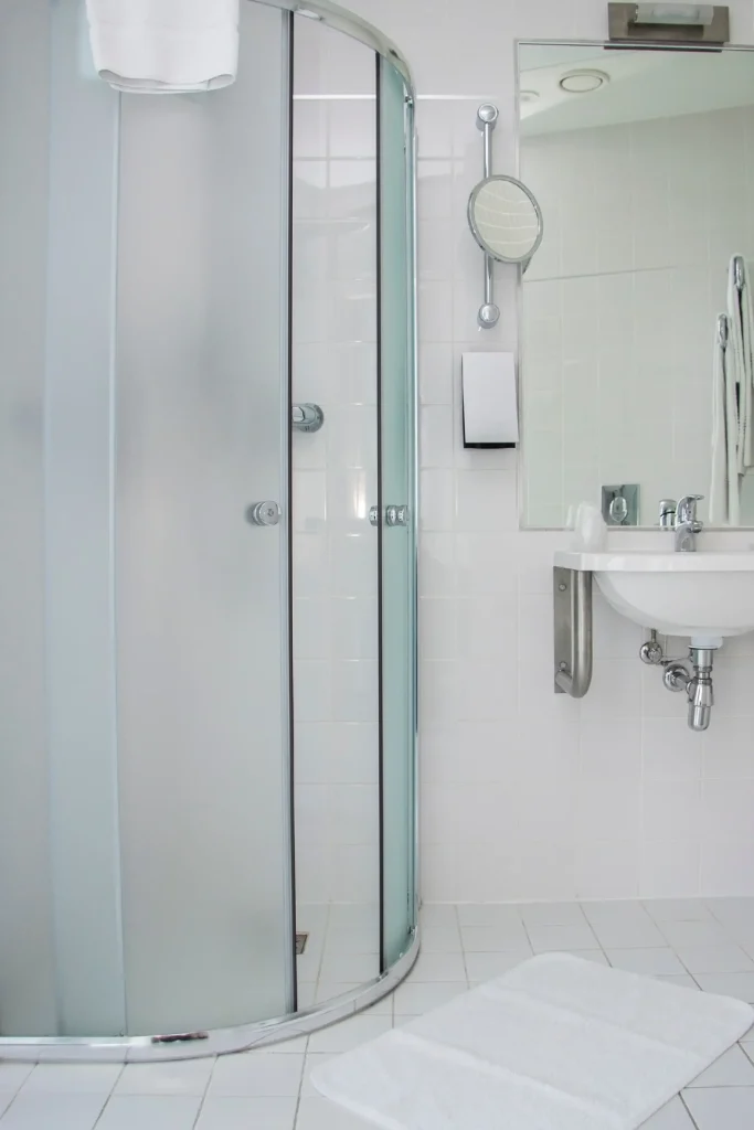 bathroom showing a shower with frosted shower doors and windows
