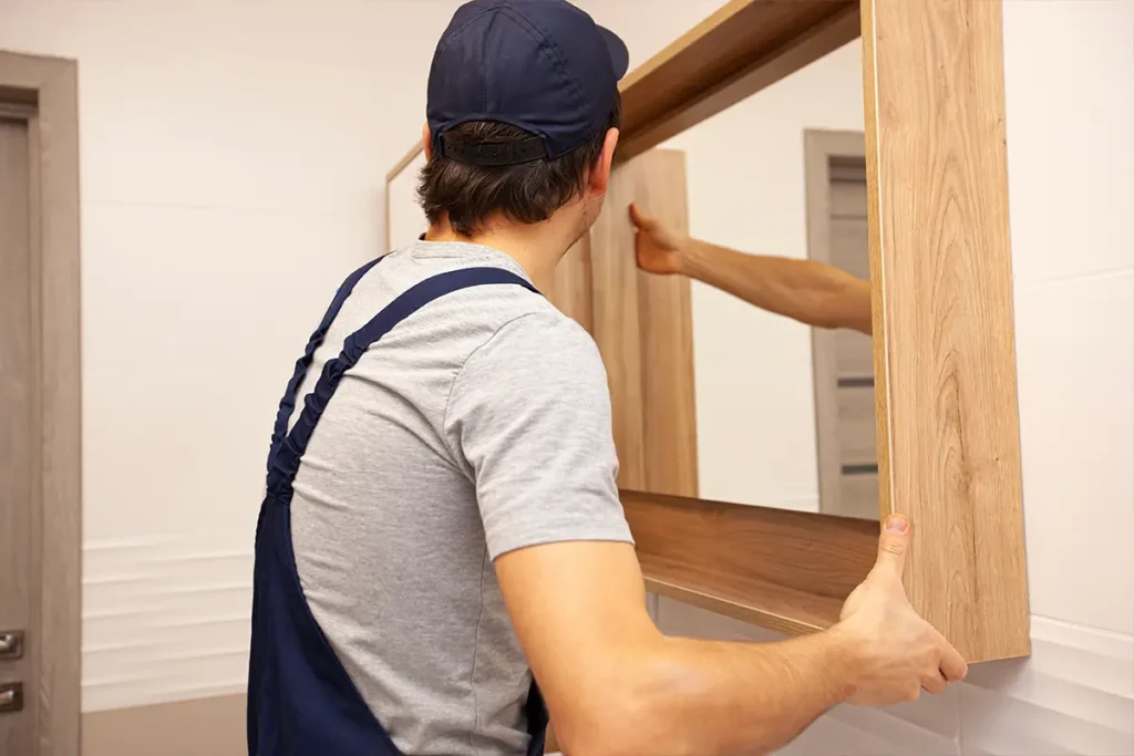 Professional installing a mirror in the bathroom