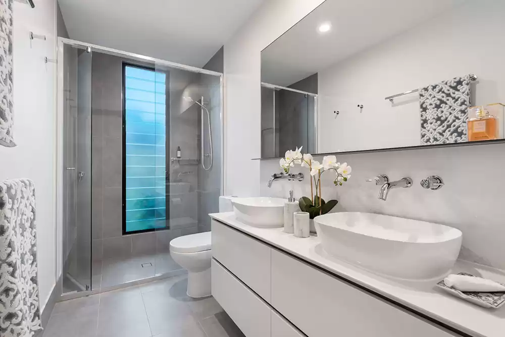 A white ceramic sink and clean glass shower door