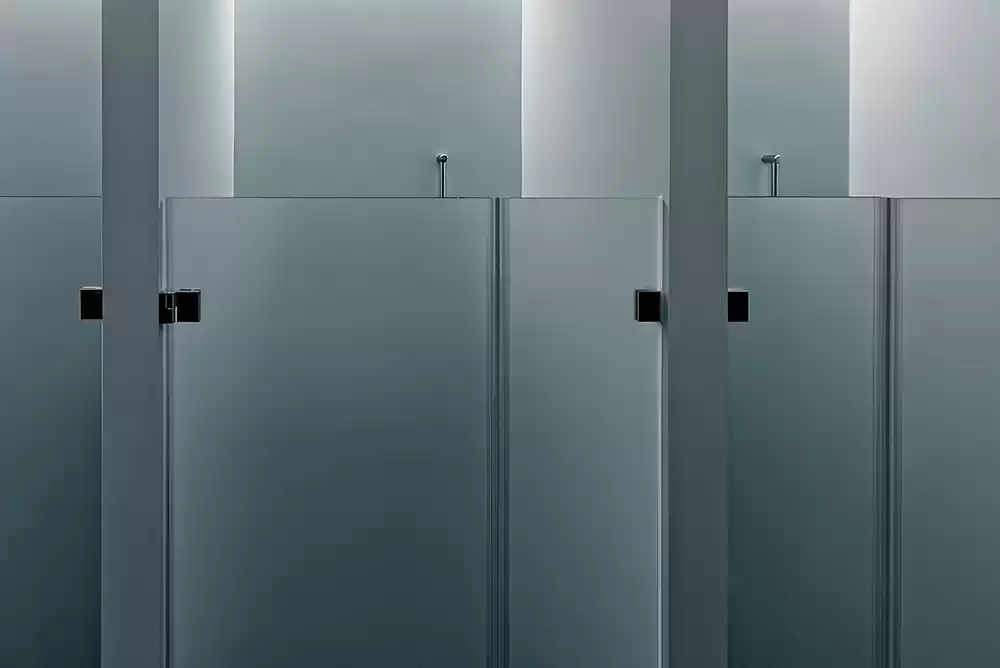 frameless glass shower doors utilized at a public restroom