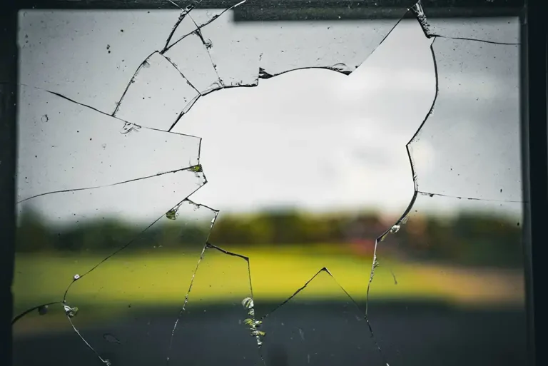 a broken window with a blurry landscape in the background