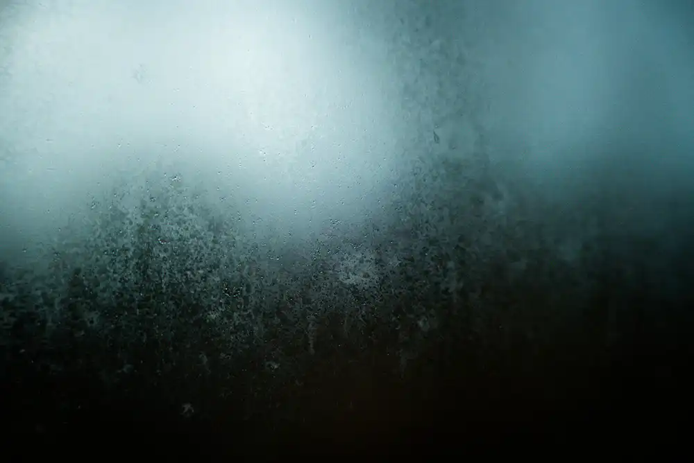 A photo of a foggy window with condensation on it
