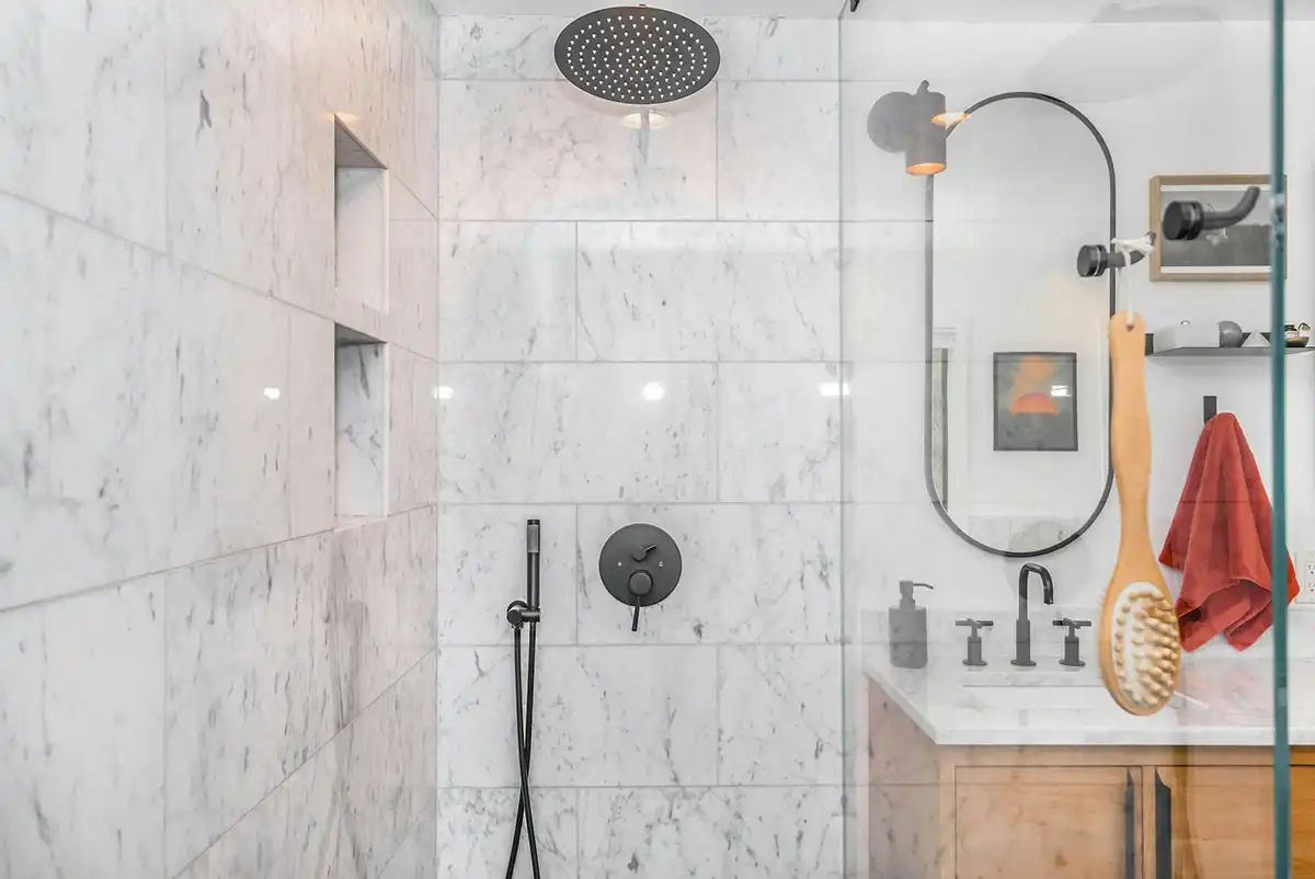 black shower head on white ceramic wall tiles